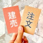 「注文」「建売」と書かれたメモを持つ手